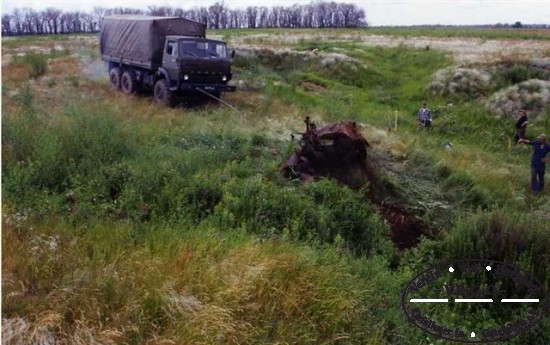 unter Zuhilfenahme von schwerem Gert wird ein ehemaliger Unterstand von dem Fahrgestell eines Wehrmachts LKWs befreit. Unter dem LKW konnten Soldaten geborgen werden